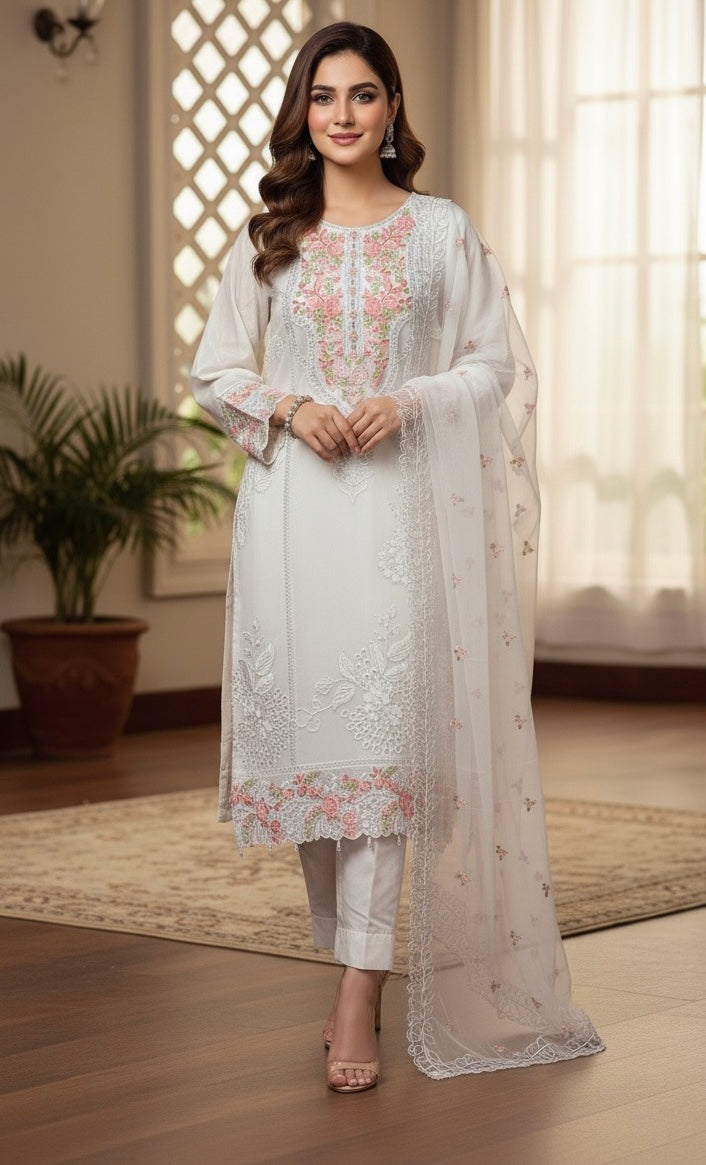 A sophisticated silk-blend suit featuring intricate tone-on-tone floral cutwork and contrasting bright thread embroidery on the neckline and dupatta.