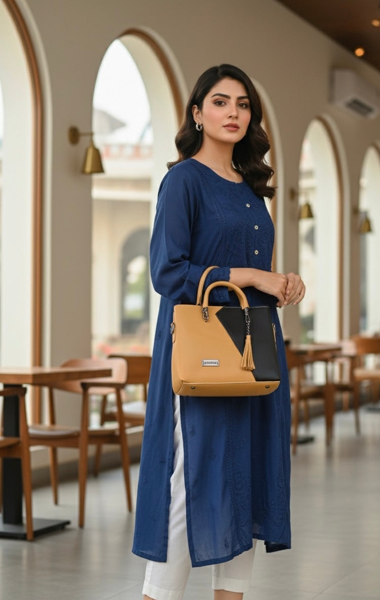top-handle handbag with a distinctive two-tone color block design and a tassel charm accent 💼
